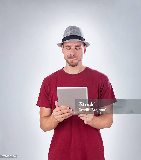 Frowned Człowiek Confusedly Patrząc Na Tablet Pc Z Kopii Przestrzeni - zdjęcia stockowe i więcej obrazów Codzienne ubranie