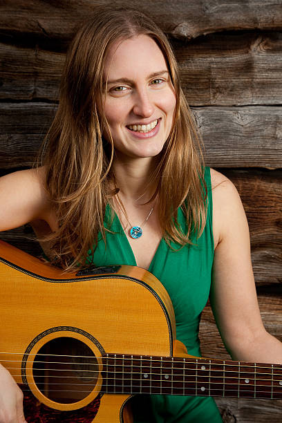 istock Woman smiling playing guitar 177040349