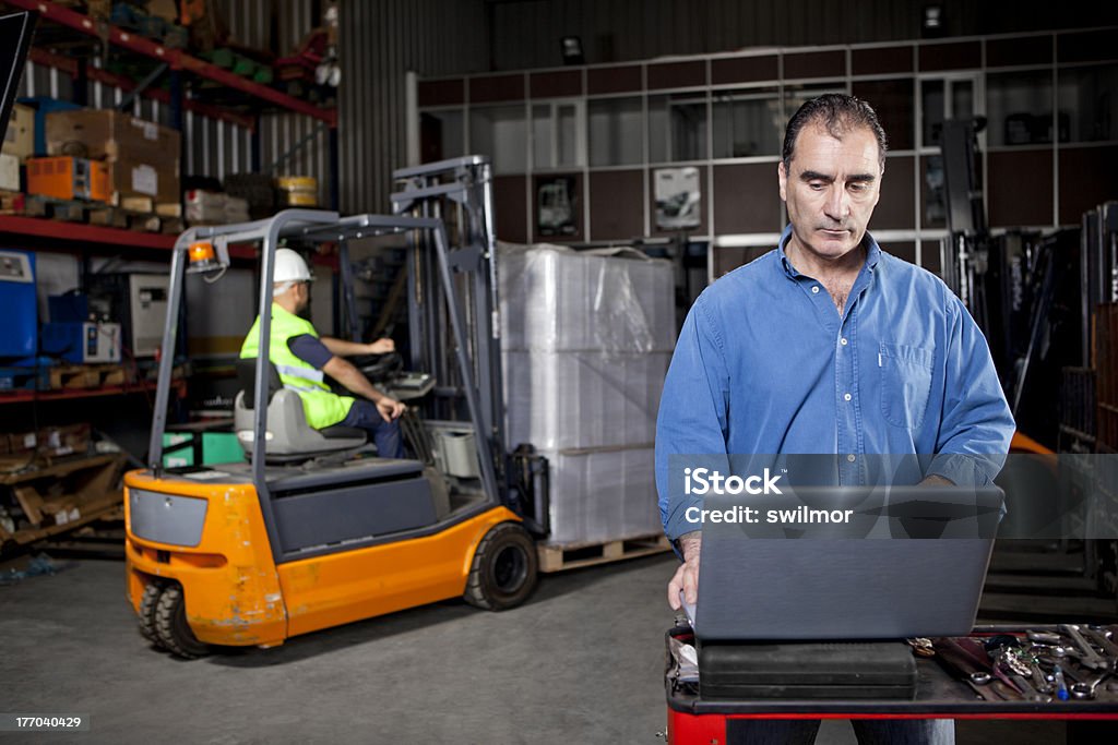 Homme travaillant sur ordinateur portable dans un entrepôt - Photo de Activité avec mouvement libre de droits