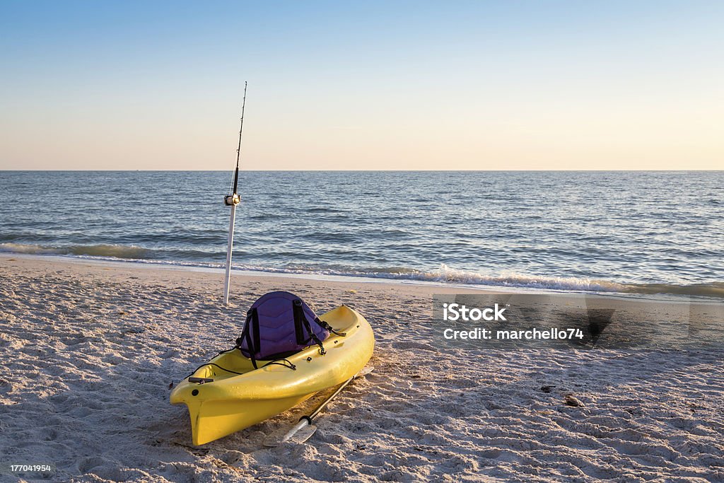 Bastone da pesca e canoa sulla spiaggia - Foto stock royalty-free di Industria della pesca