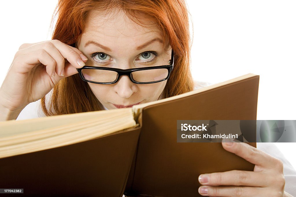 Beautiful red-haired girl in glasses reads book. Beautiful red-haired girl in glasses reads book on a white background. Adult Stock Photo