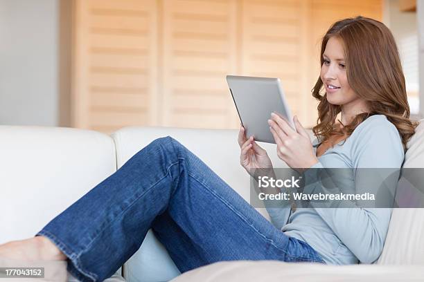 Foto de Mulher Lendo Ebook No Sofá e mais fotos de stock de 25-30 Anos - 25-30 Anos, Aconchegante, Adulto