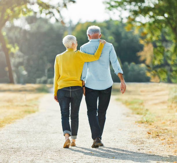 mulher homem ao ar livre casal sênior aposentadoria juntos caminhando amor de mãos dadas apoiar a velha natureza esposa felicidade maduro idoso - senior couple senior adult pension couple - fotografias e filmes do acervo