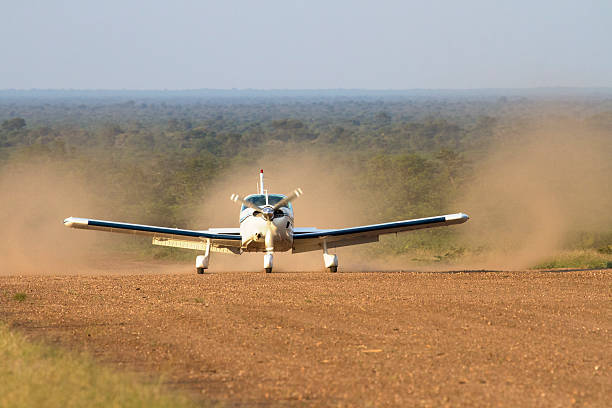 An aircraft landing on a remote dirt airstrip deep in the Botswana bush somewhere between Gabarone and Makgadikgadi.