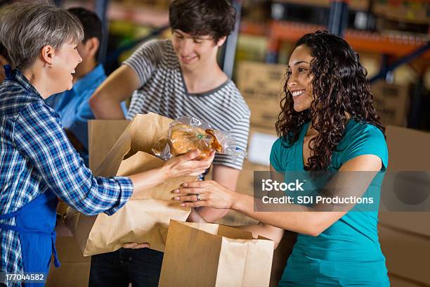 Diversos As Adolescências Volunteering No Banco Alimentar Que As Dádivas - Fotografias de stock e mais imagens de Assistência