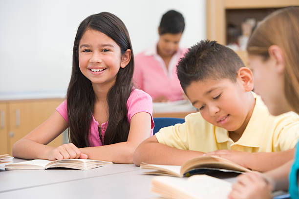 Group of elementary school pupils Group of elementary school pupils reading smiling boy and girl reading stock pictures, royalty-free photos & images