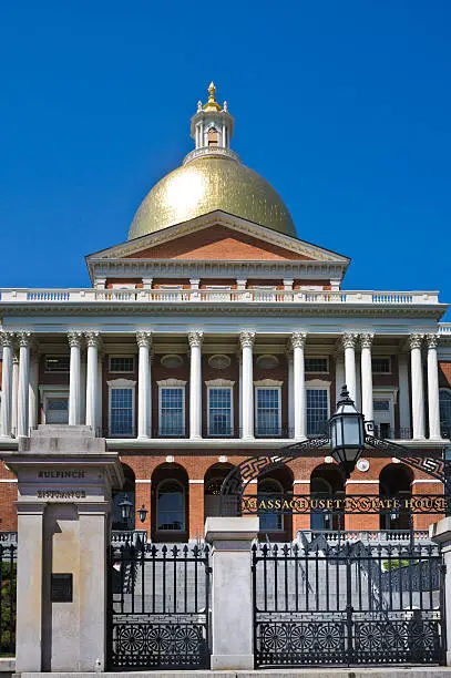 Afternoon sunlight bounces off the Charles Bullfinch designed gold dome of the Massachusetts Statehouse in Boston (1798) at the top of Beacon Hill