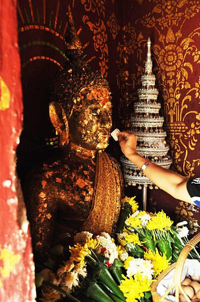 istock putting  gold leaf onto the Buddha image 177047592