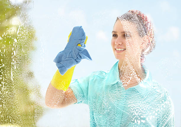 Making sure it's clean and streak-free Young woman washing her windows with a smile do rag stock pictures, royalty-free photos & images