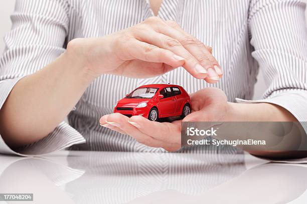 Due Mani Proteggendo Una Piccola Rosso Il Modello - Fotografie stock e altre immagini di Automobile - Automobile, Misure di sicurezza, Protezione
