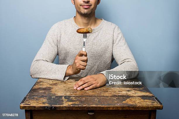 Photo libre de droit de Jeune Homme Manger Des Saucisses banque d'images et plus d'images libres de droit de Manger - Manger, Saucisse, Aliment