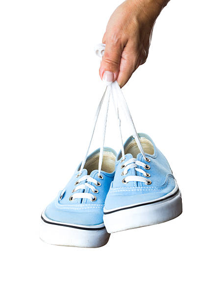 istock Woman hand holding sneakers on white background 177048480