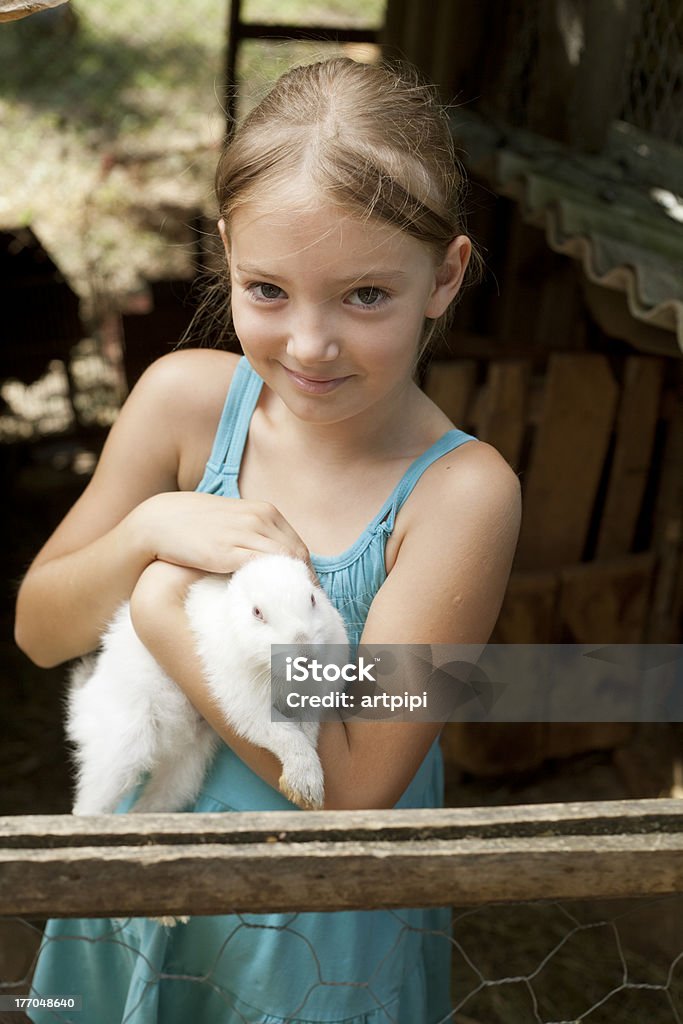 Linda chica sosteniendo white rabbit - Foto de stock de 10-11 años libre de derechos