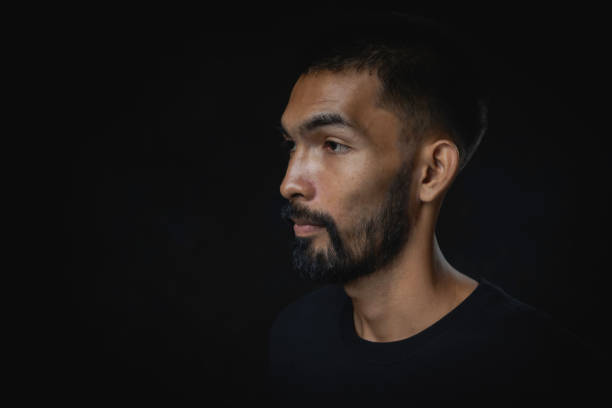 istock Portrait serious young man with beard looking away against a black background 1770488954