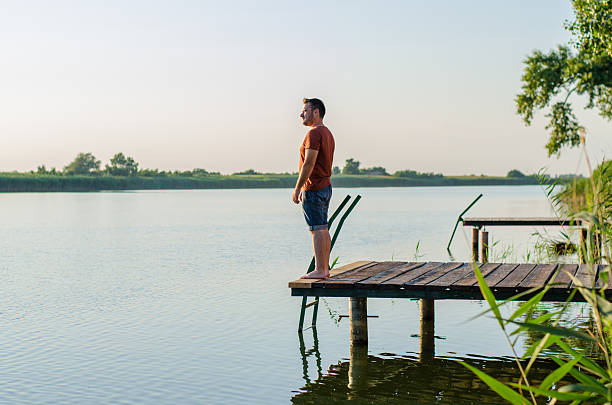 istock Young man standing relaxing and enjoying the view from dock 177050205