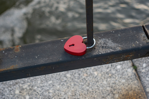 A heart-A heart-shaped castle on the bridge railing is a romantic city tradition.shaped lock on the bridge railing is a romantic tradition