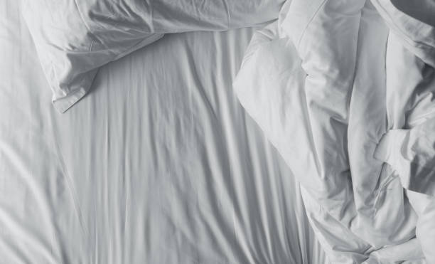Top view of messy bedding sheets and pillow