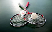Two shuttlecocks and badminton racket on court floor