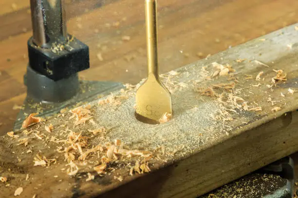 Wood drilling spade bit drilling into a wood beam