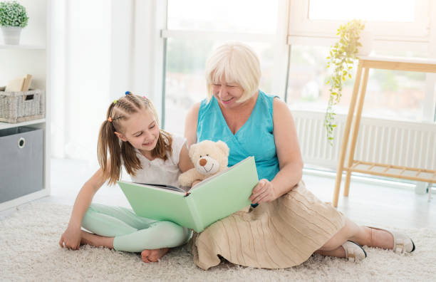 istock Granny reading book to little granddaughter 1770535111