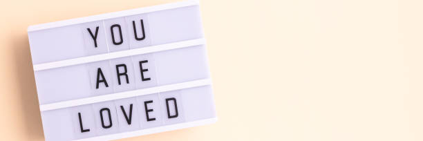 istock You are loved. Banner with lightbox with letters on a beige background. 1770540636