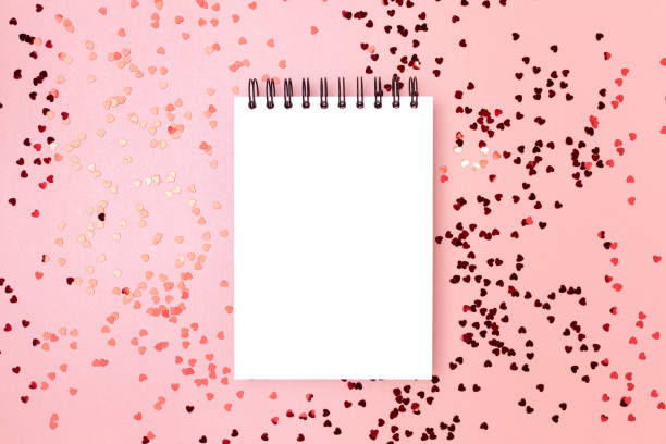 istock Blank notepad mockup with red metallic hearts confetti. 1770546102