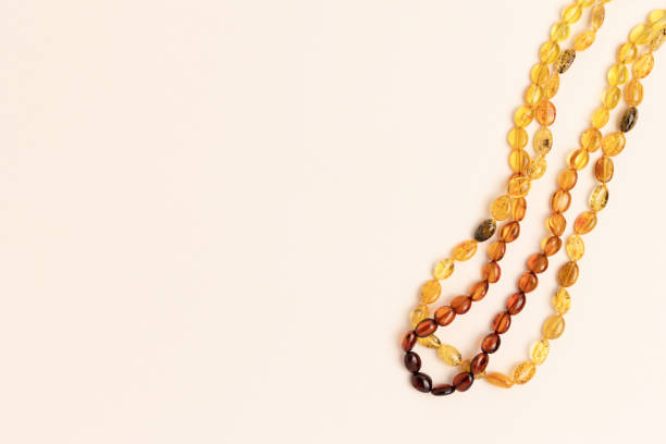 Amber beads laid on a beige background. Composition with copy space.