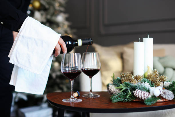 istock hand pour Red wine glasses on christmas table 1770555216