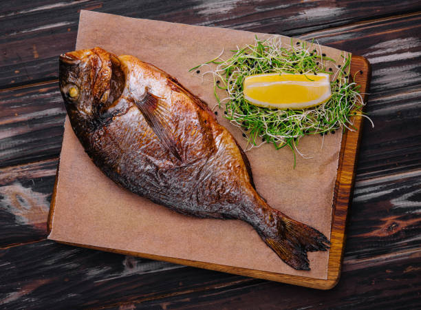 istock Board with fried dorado on wooden background 1770559006