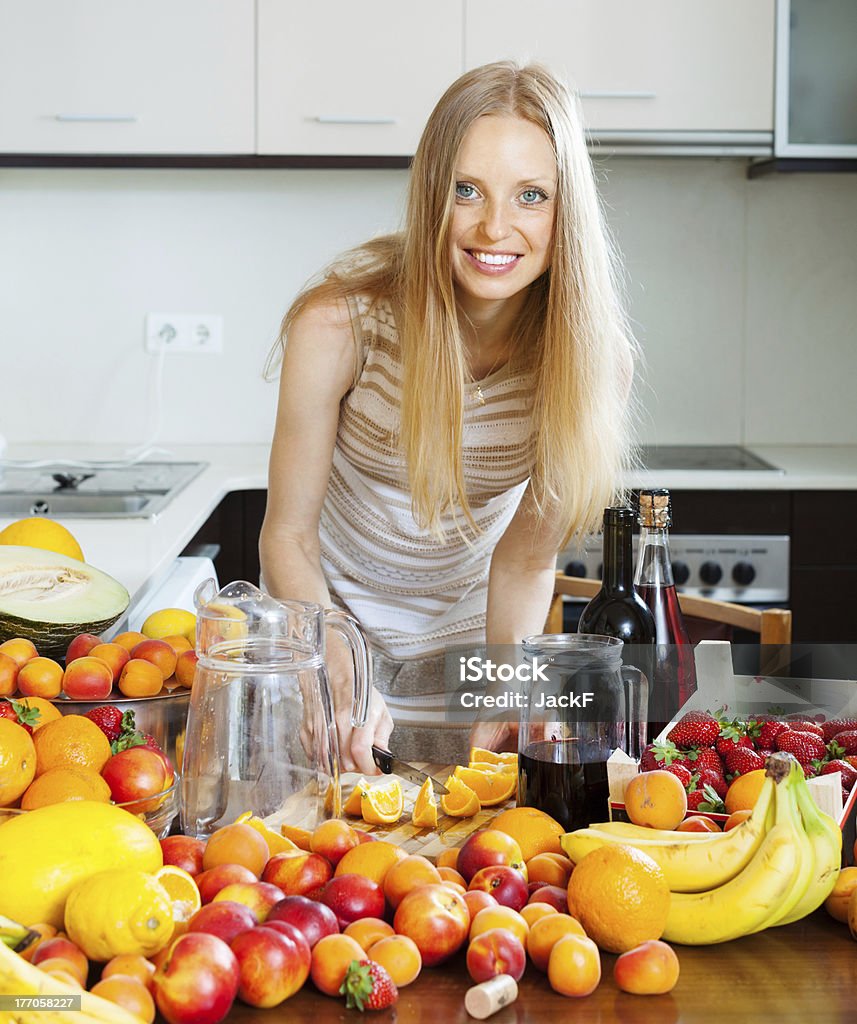 cheerful  housewife making  cocktail cheerful  housewife making alcoholic cocktail with fruits Adult Stock Photo