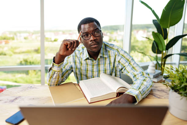 istock Serious concentrated african man studying or working with laptop indoors 1770584809