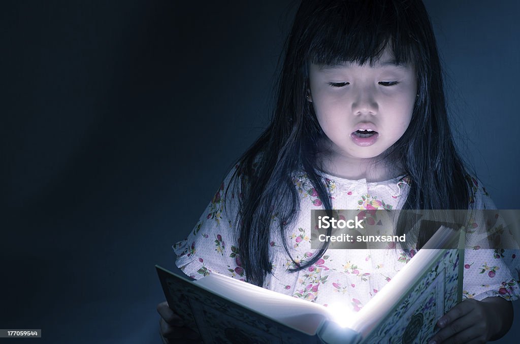 Menina lendo livro em fundo escuro - Foto de stock de Aluna royalty-free