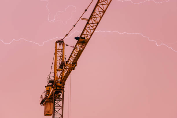 Crane and lightning, powerful thunderbolt. Weather risk assessments for the construction industry and built environment