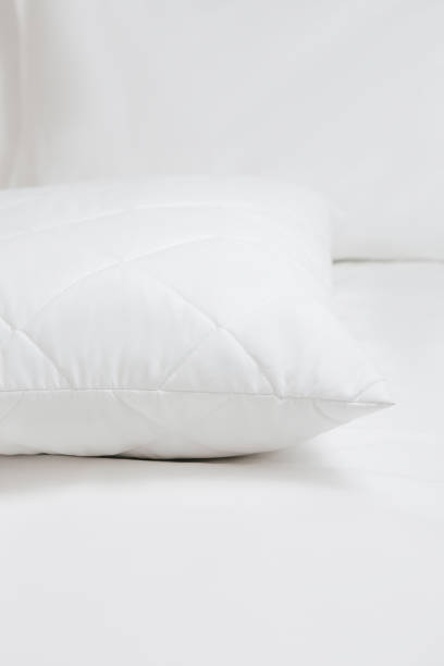 istock White quilted pillow on a white bedding white background. Cushion. Home textile. Macro photo 1770608383