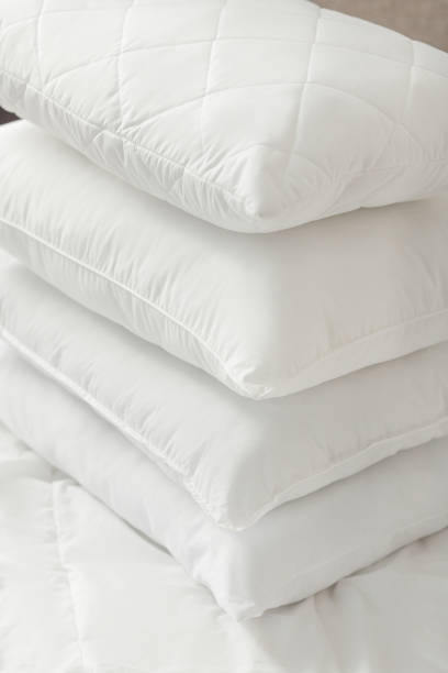 istock Different types of white bed pillows on a white bed. Pillow menu. Cushions. Home textile 1770608384