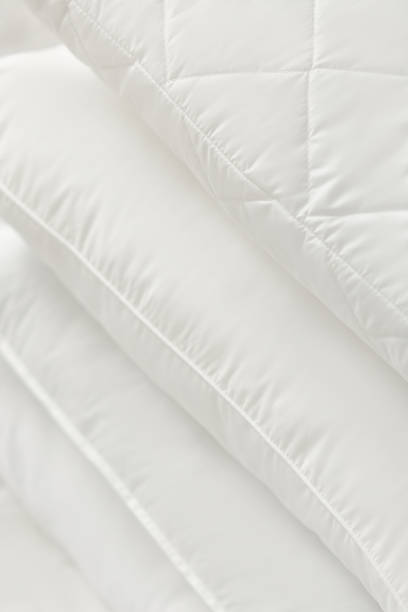 istock Different types of white bed pillows on a white bed. Pillow menu. Cushions. Home textile 1770608930