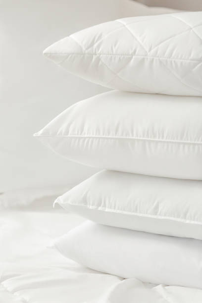 istock Different types of white bed pillows on a white bed. Pillow menu. Cushions. Home textile 1770608936