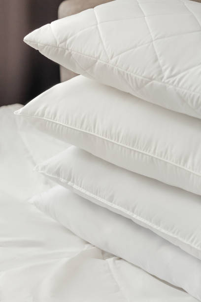 istock Different types of white bed pillows on a white bed. Pillow menu. Cushions. Home textile 1770608937