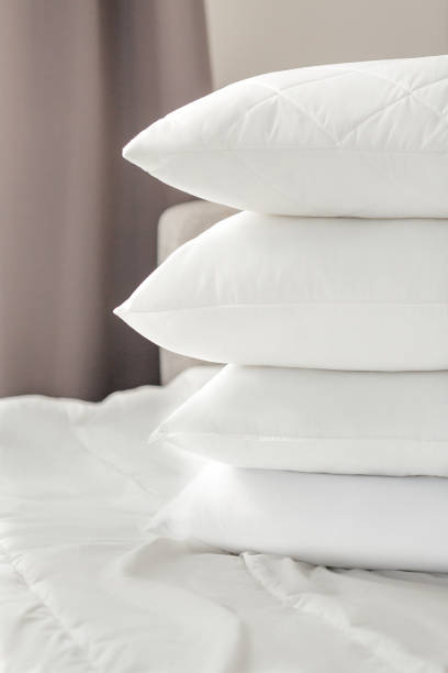 istock Different types of white bed pillows on a white bed. Pillow menu. Cushions. Home textile 1770609522