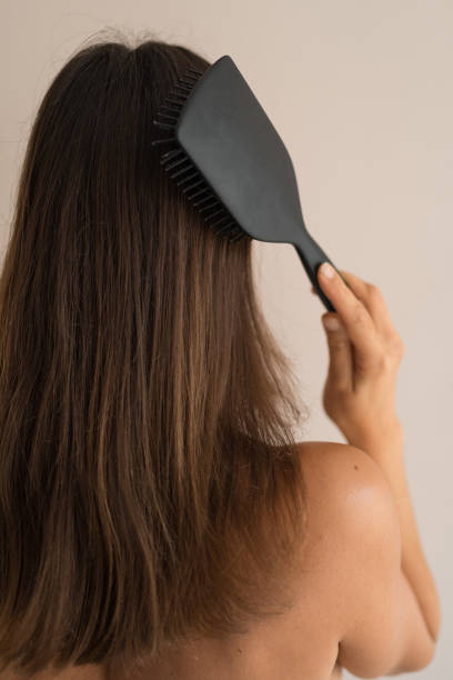 istock Young woman brushes hair 1770615077