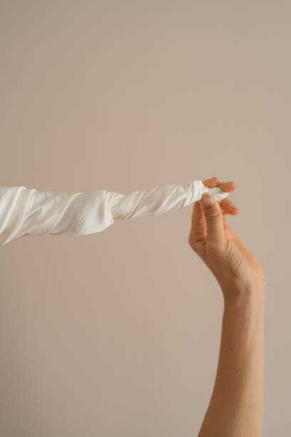 istock Hand holds long, white, twisted ribbon 1770615589