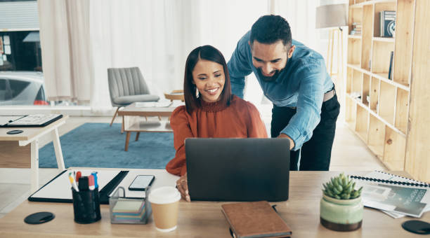 istock Creative people, laptop and coaching in planning, teamwork or collaboration together at office. Man helping or training woman or staff on computer in project startup, ideas or strategy at workplace 1770663427