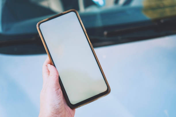 istock Hand holding an android smart phone near a car 1770665746