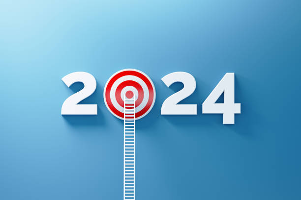 istock 2024 Resolutions Concept - White Ladder Leaning onto A Red Bull's Eye Target and 2024 Written by Numbers on Blue Wall 1770675013