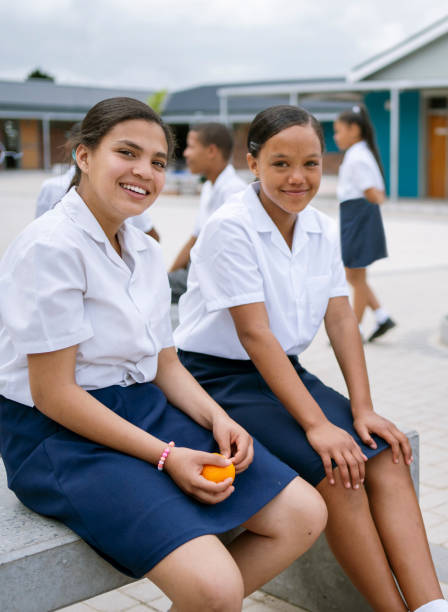 istock Two young female students sitting out on school campus during break 1770683156