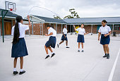 School children playing jump rope game in school yard during recess
