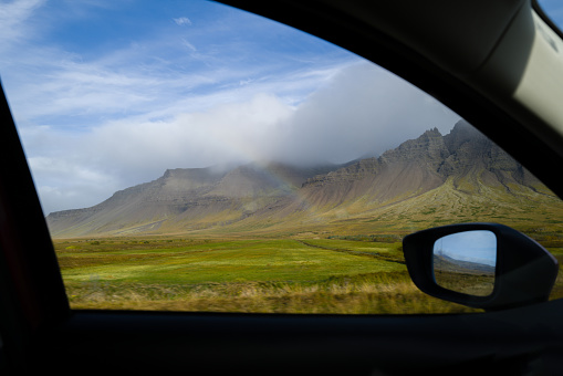 Rainbow on the green field near mountains in Iceland