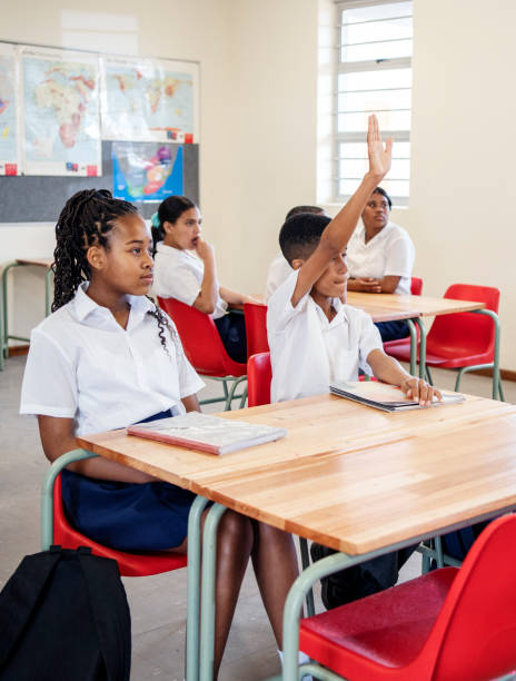 istock School boy raising hand to answer teacher's question in classroom 1770684879