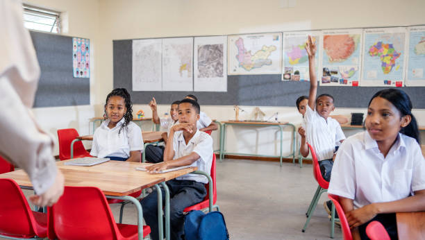 istock Pupils raising hands to answer question in classroom 1770685953