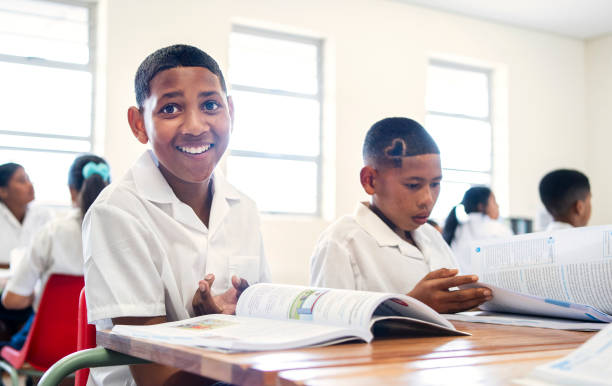 istock Smiling boy sitting at his desk with textbook during lecture in classroom 1770687595